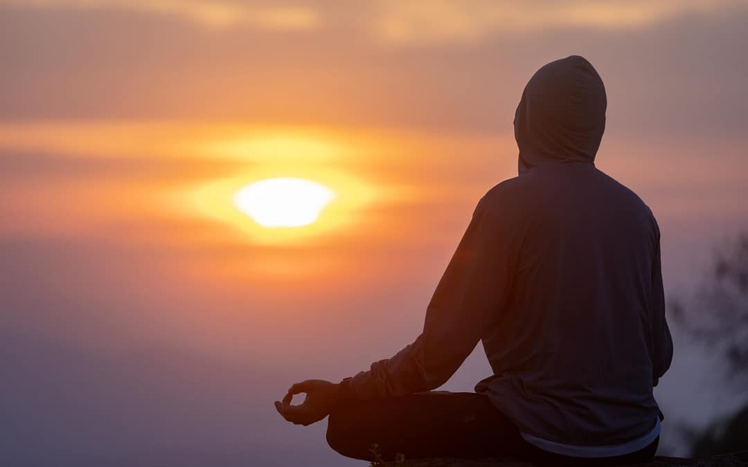 Person meditating in nature during a personal meditation retreat.